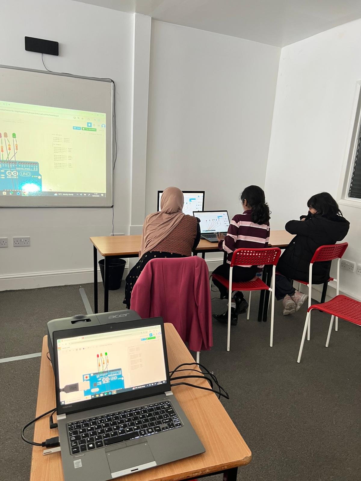 Students using laptops to learn Arduino and coding concepts