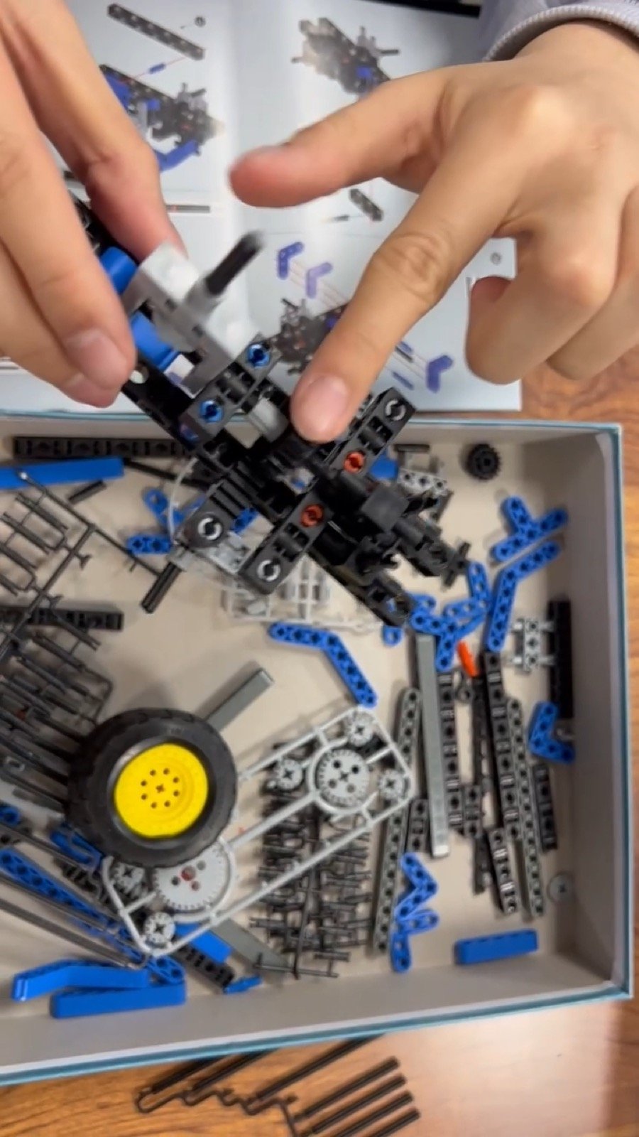 Hands assembling robot parts during a STEM activity