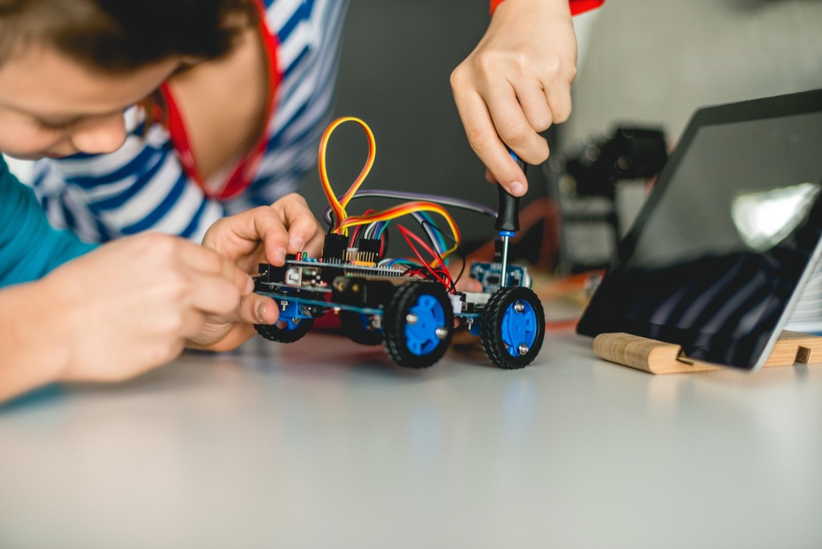 Close-up of a robotics build activity with tools and wiring